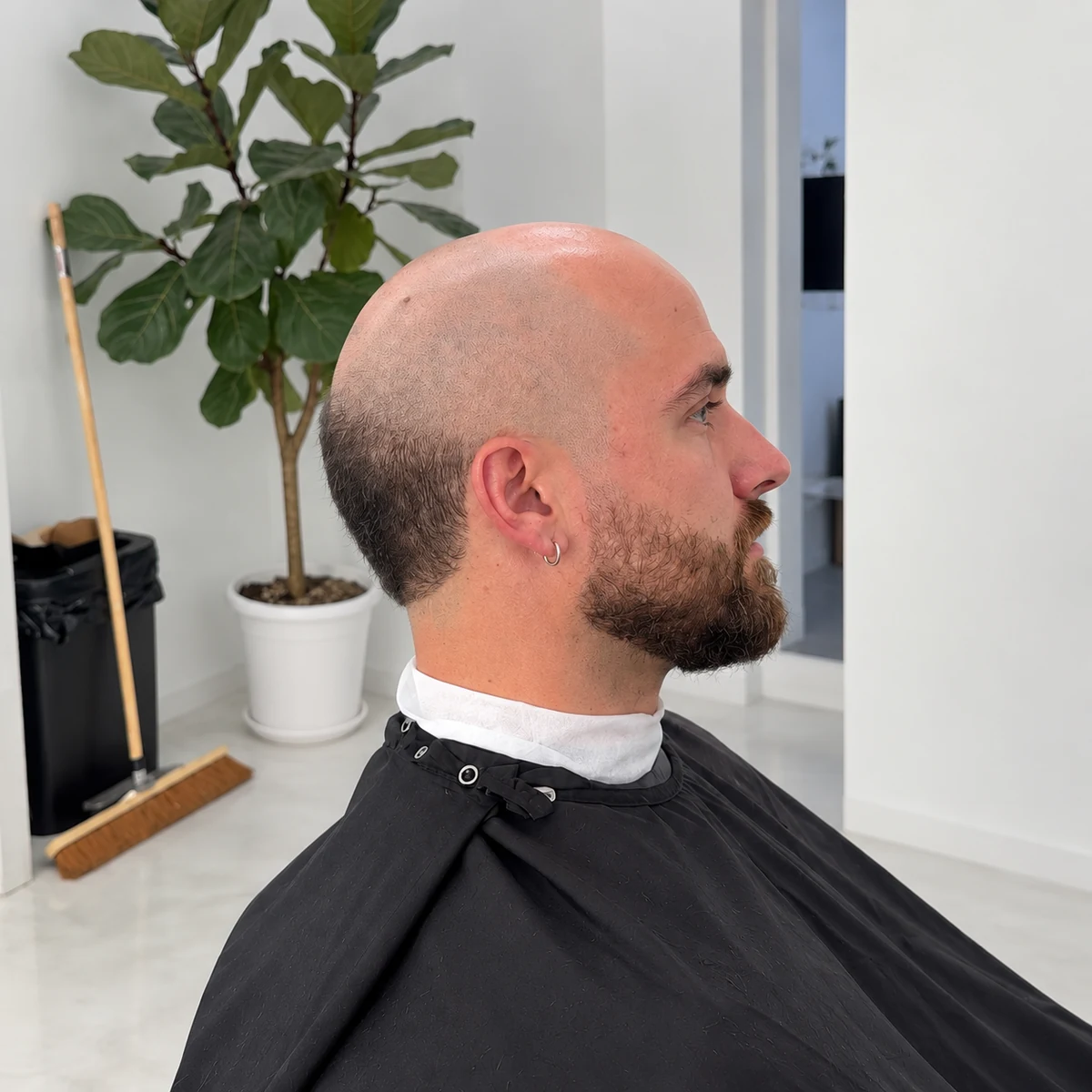 Dégradé calvitie avec couronne courte et barbe brune, de profil